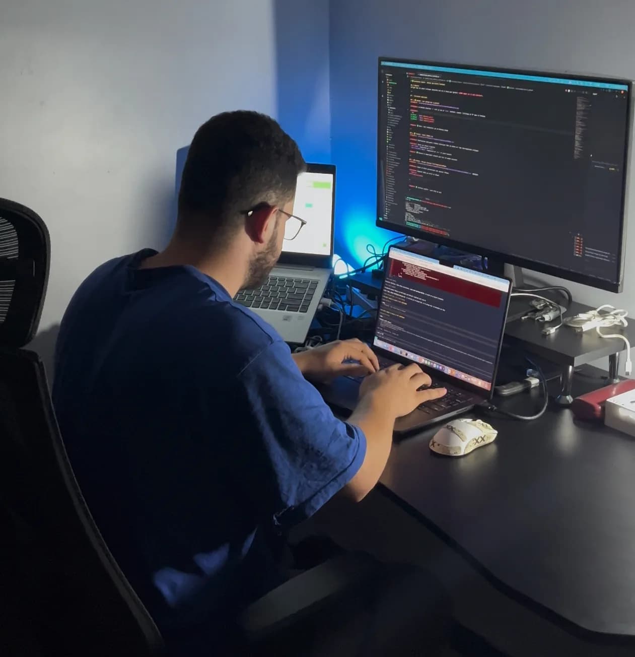 Zakaria Braham au travail à son bureau, devant son écran et son ordinateur portable